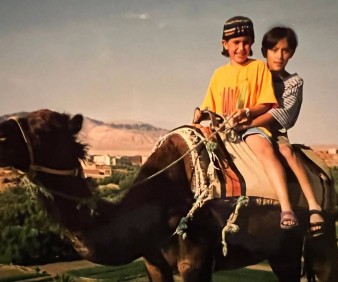 Kids riding camels in Morocco